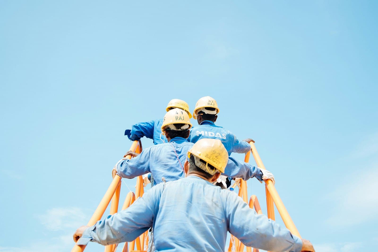 Crew in hard hats climbing scaffolding on a job site